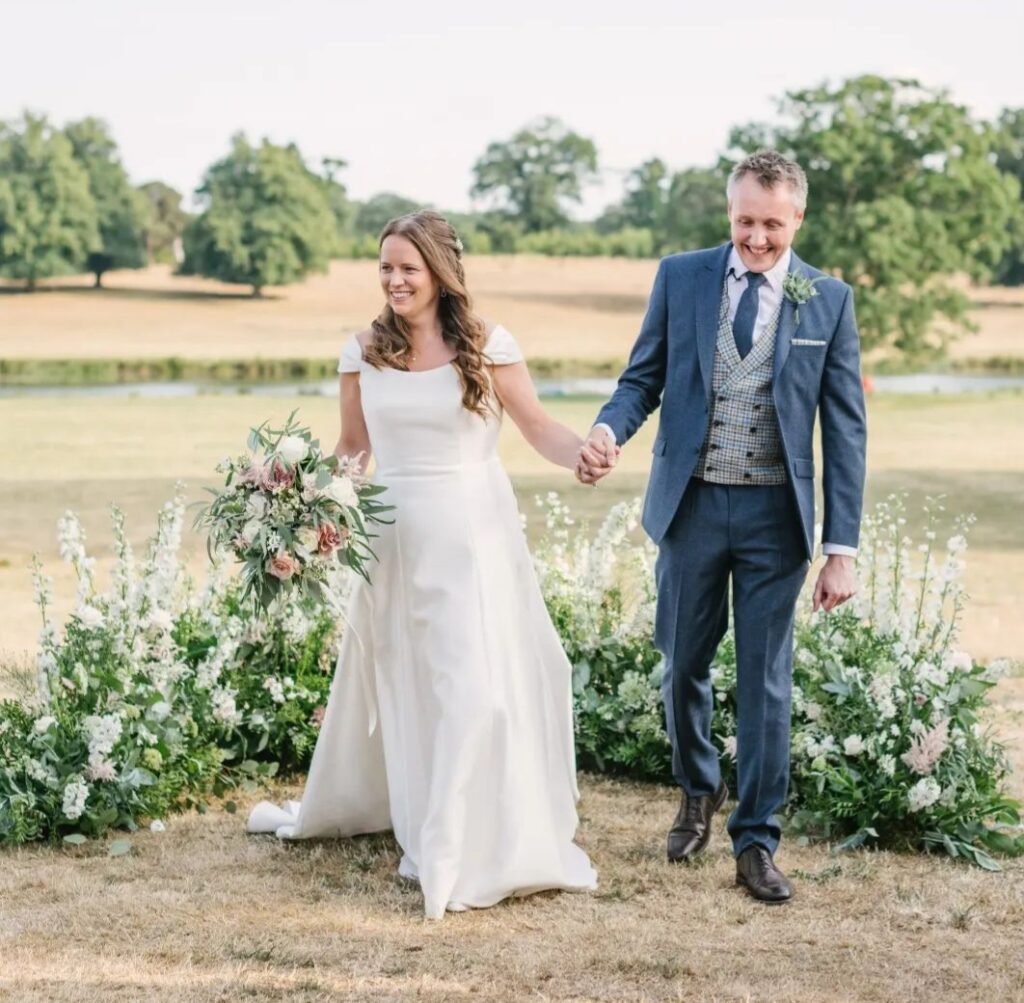 Grounded ceremony arch in natural elegant white flowers including delphinium at Wilderness Reserve wedding venue Suffolk