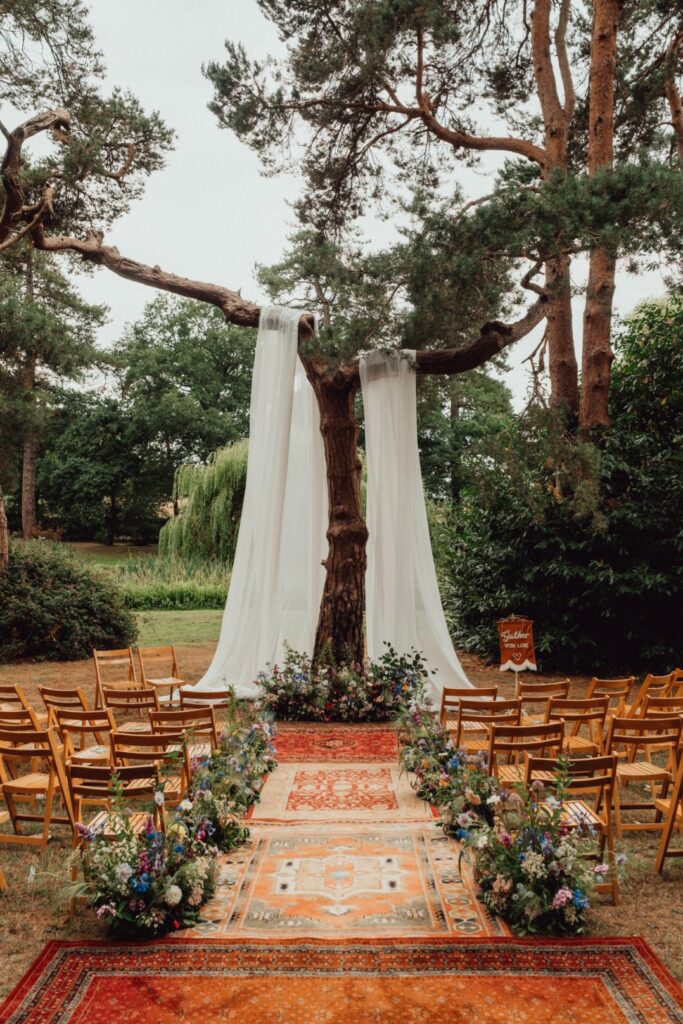 Happy Valley Woodland Venue in Norfolk. Outdoor ceremony dressed with colourful natural summer meadow flowers.