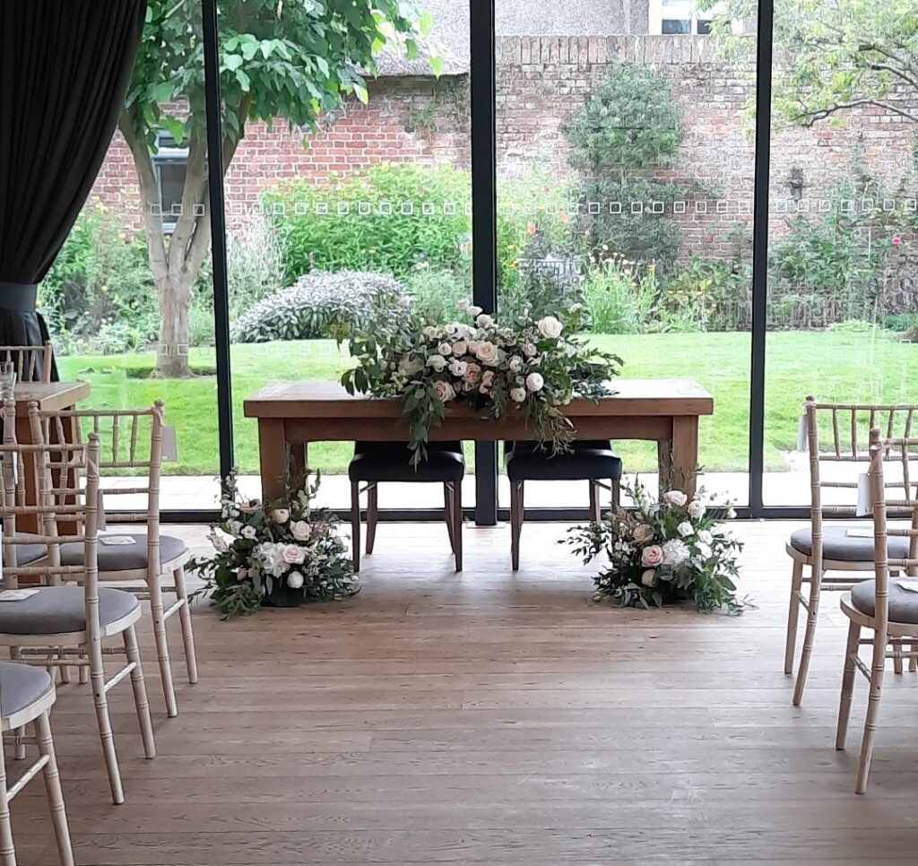 Wedding ceremjny flowers at The Norfolk Mead Hotel wedding venue Norfolk. Featuring a natural cascading design and floor level floral meadows