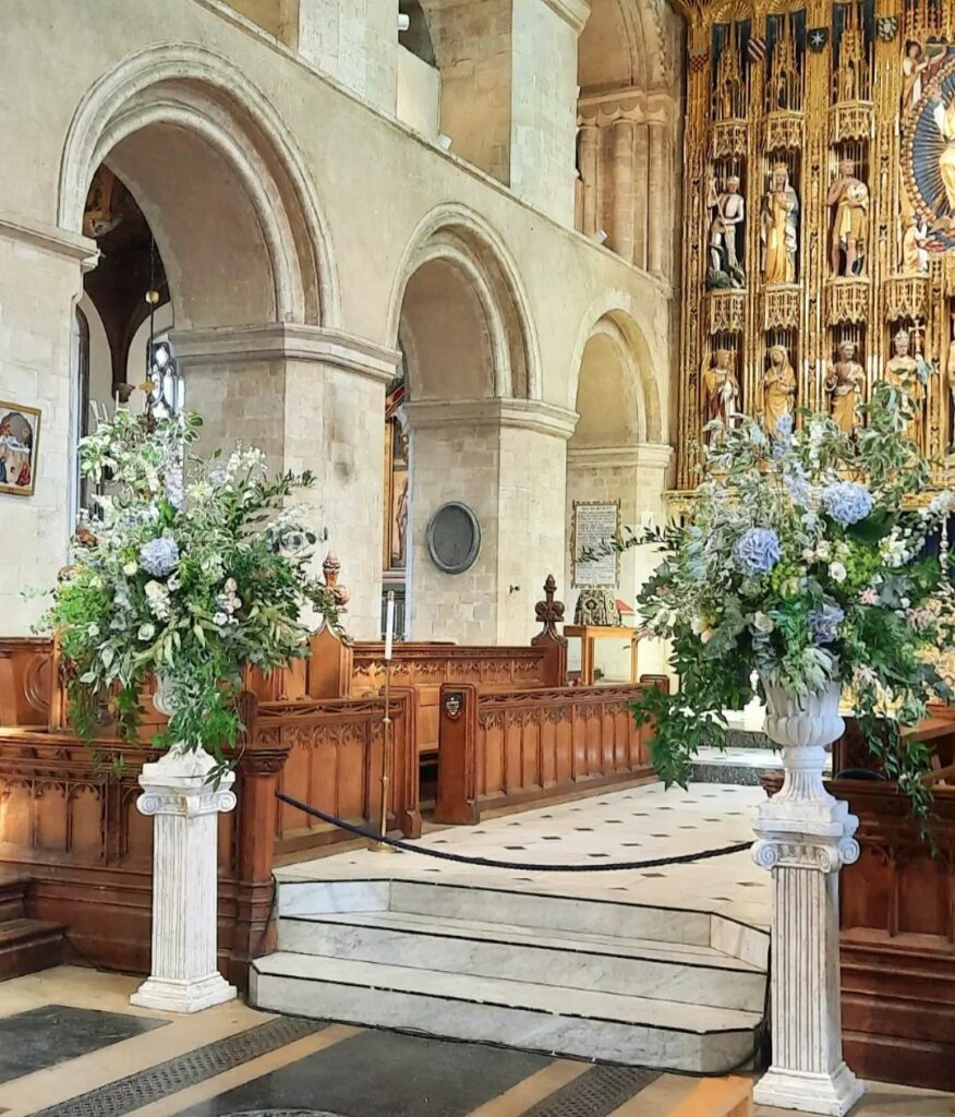 Statement urns filled with soft blue and white summer florals at Wymondham Abbey Norfolk