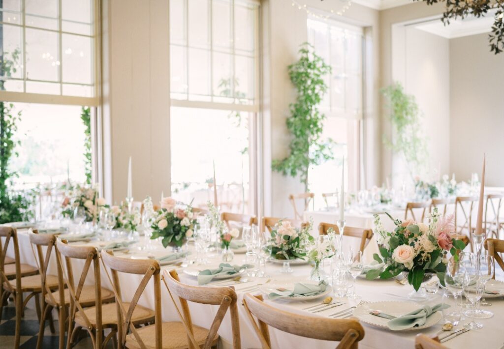 Table flower dressing at Wilderness Reserve wedding venue in Suffolk. Featuring raised bowl designs and bud vases of flowers on long tables