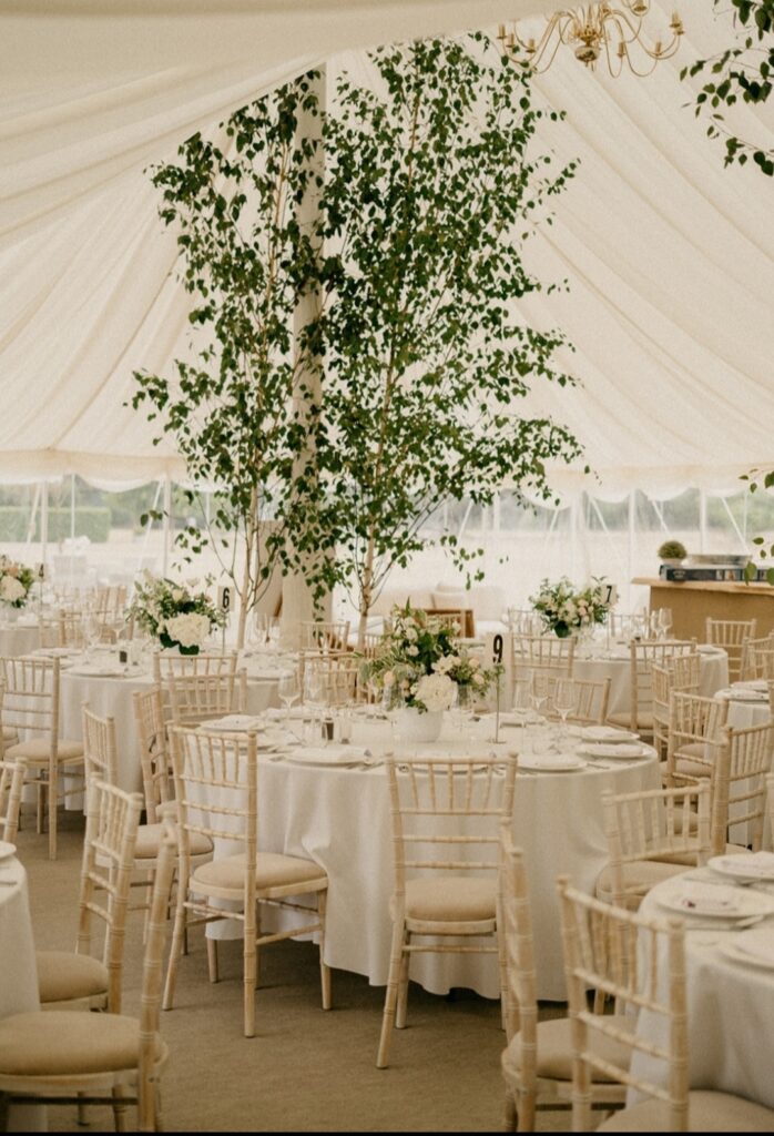 Marquee wedding natural table arrangements enhanced with tall birch trees
