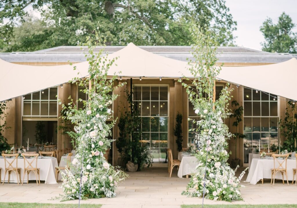 Elegant deconstructed arch of fresh flowers and foliage at Wilderness Reserve wedding venue Suffolk