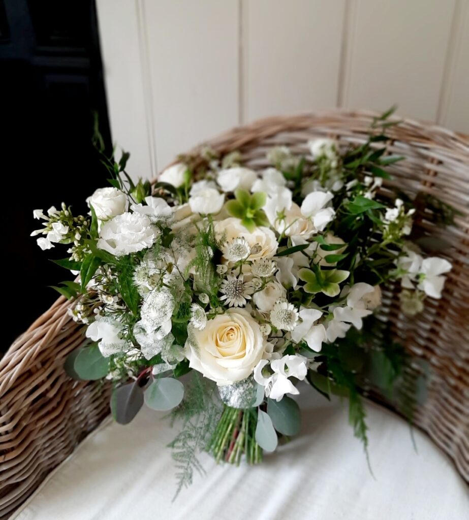Delicate spring white and green Bridal Bouquet. Featuring roses and hellebore 