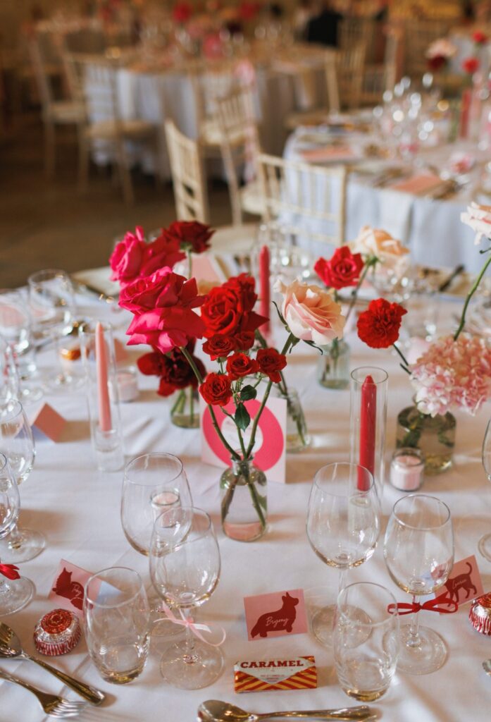 Fun bright table bud vases in shades of red, burgundy and blush pink for Kellies wedding at Manor Mews