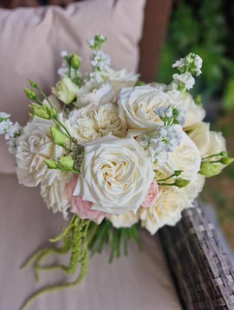 Modern bridal bouquet including blousy roses and trailing amaranthus