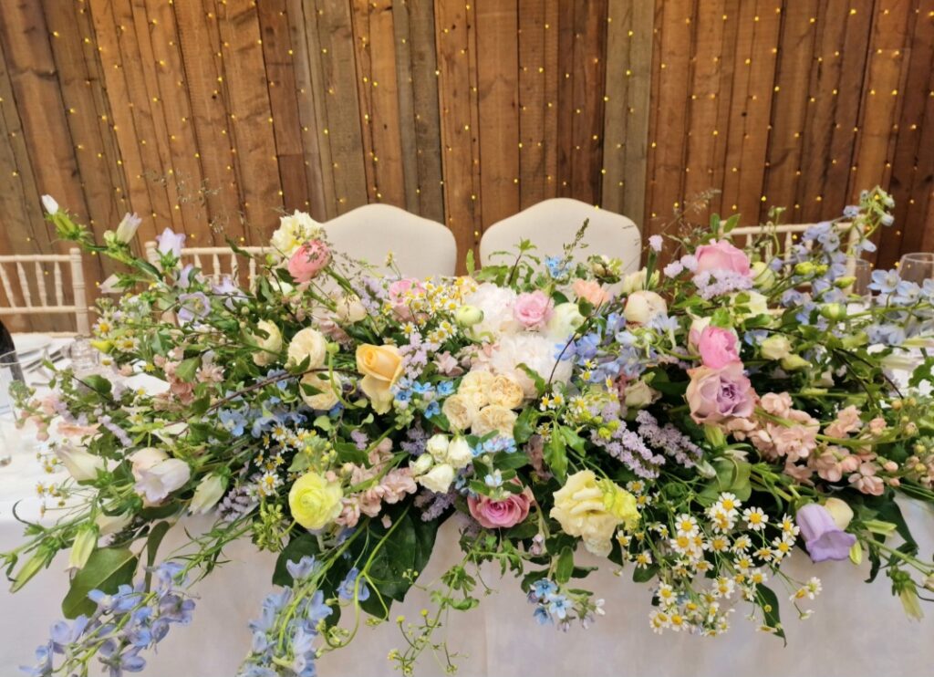 Top table long cascading arrangement in pastel shades at Oxnead Hall 